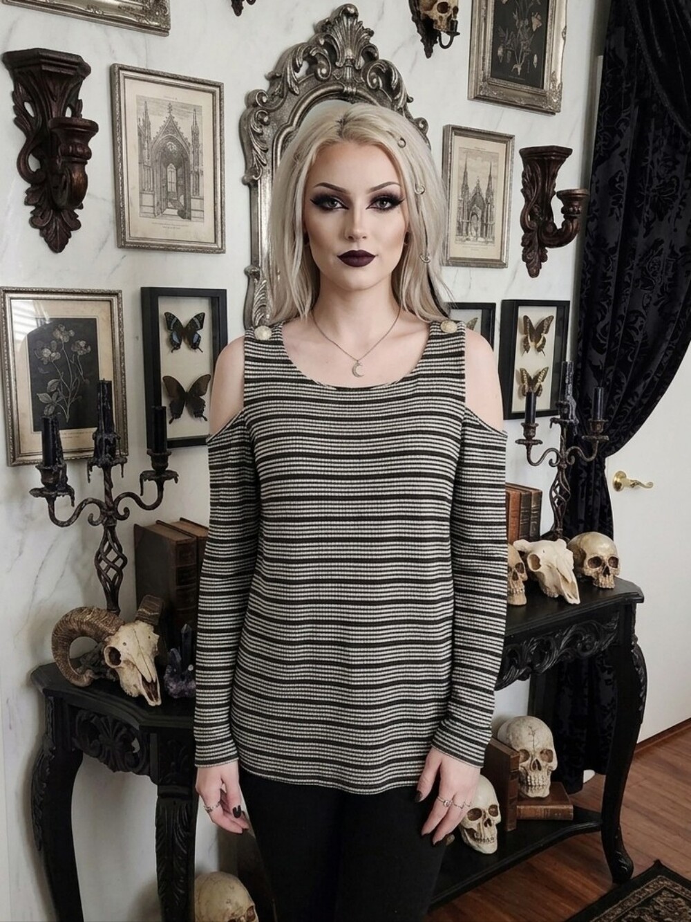 Striped black and white cold-shoulder long-sleeve knit top with button accents.
